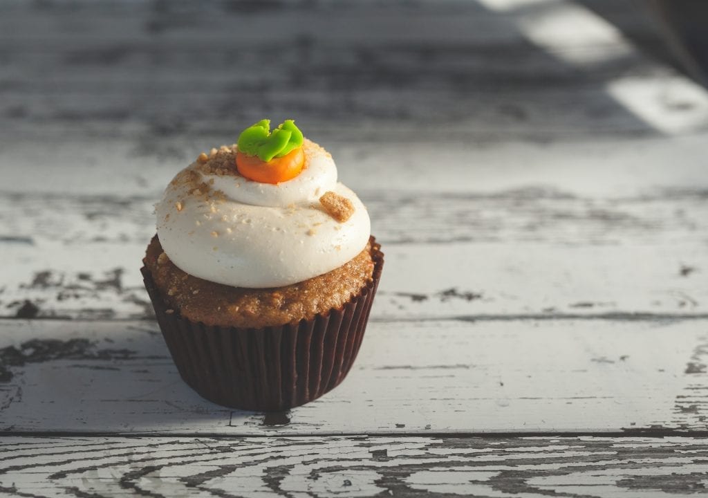 Cannabis infused pumpkin spice cupcakes with some orange and green icing on top of them. 