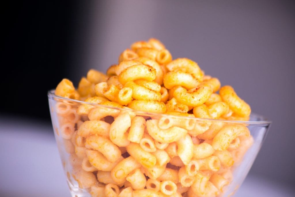 Cannabis infused macaroni and cheese on a white table in a clear bowl. A weed edible dinner recipe.