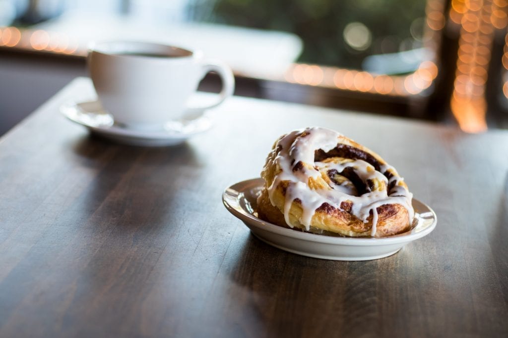 weed cinnamon rolls with white icing on the top melting over the bun. 