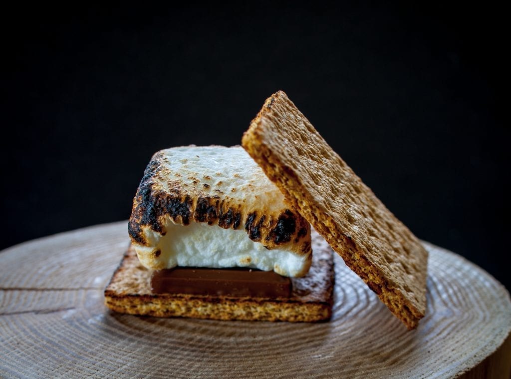 One weed smores on a log with a black background