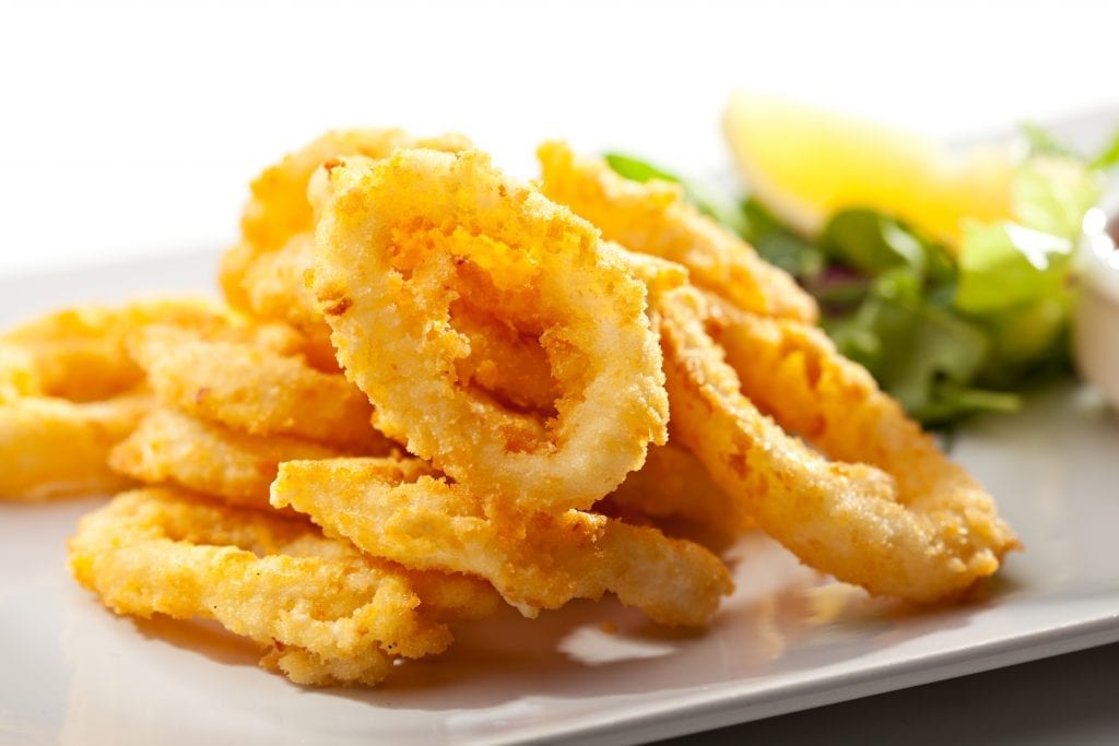 deep fried cannabis infused calamari rings with salad beside them on the plate