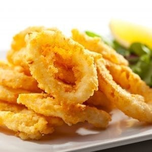 deep fried cannabis infused calamari rings with salad beside them on the plate