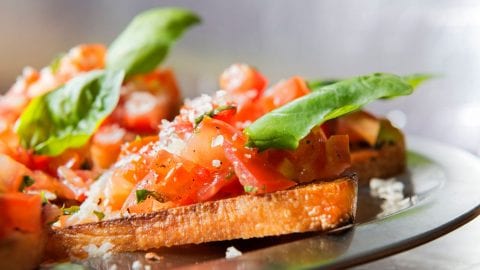 macro of cannabis infused bruschetta on a black plate