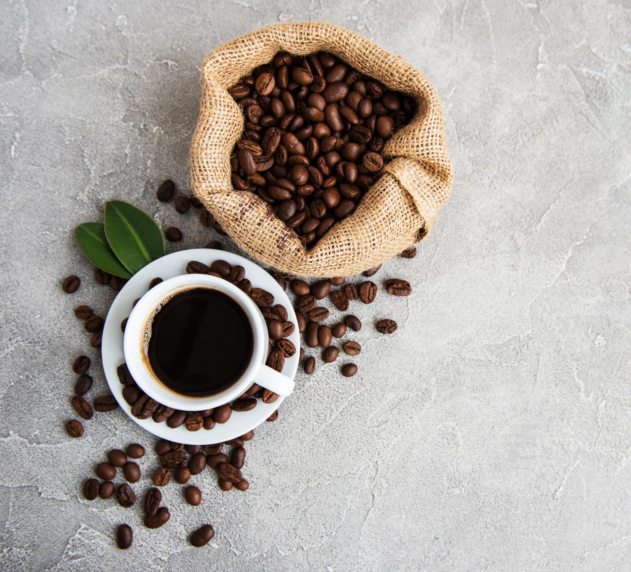 cup of weed coffee laying beside coffee beans.