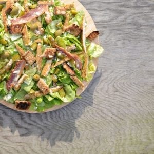 weed infused salad on a wooden cutting board on a wooden countertop