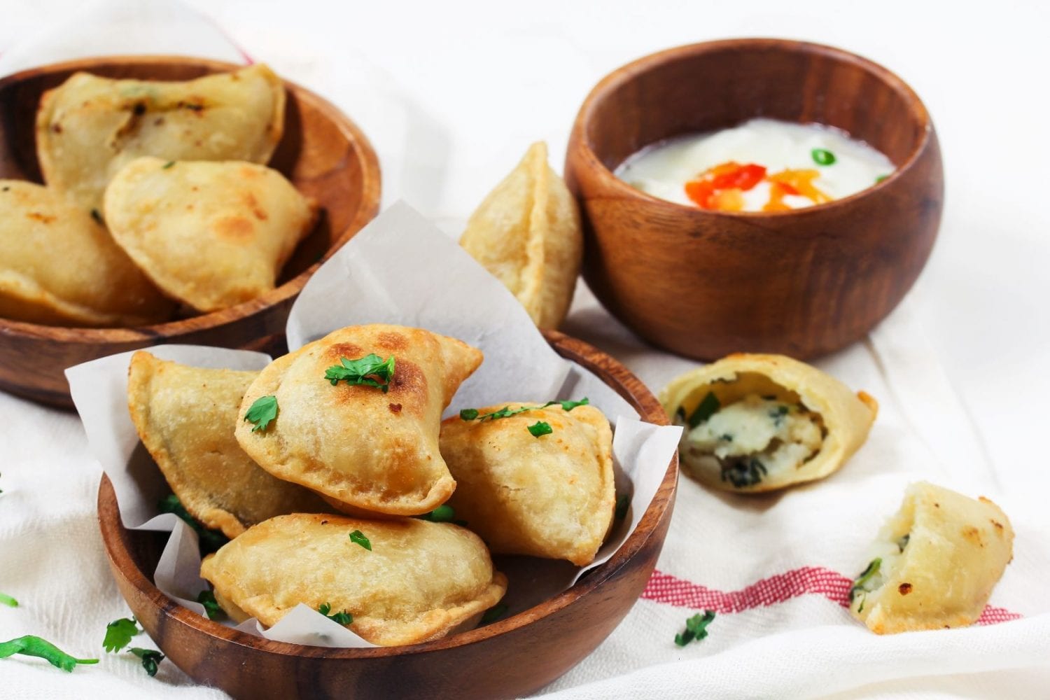 Two bowls of cannabis infused perogies With more weed pierogies beside the balls along with Tzatziki diping sauce