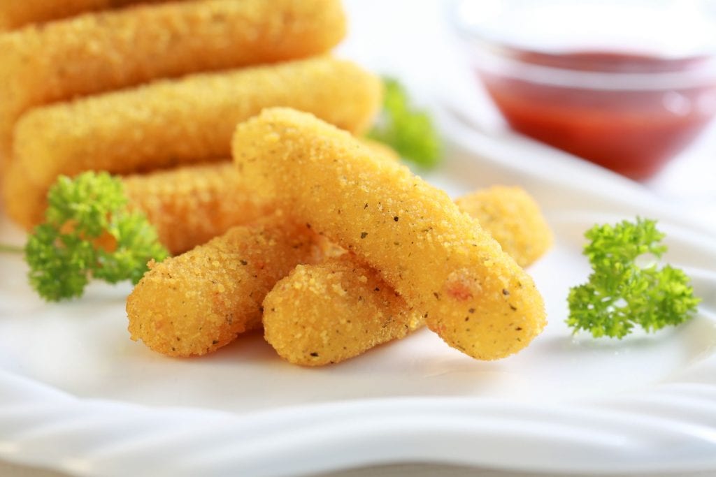 Macro shot of weed mozzarella sticks with sauce and more mozzarella sticks in the background a great weed appetizer recipe