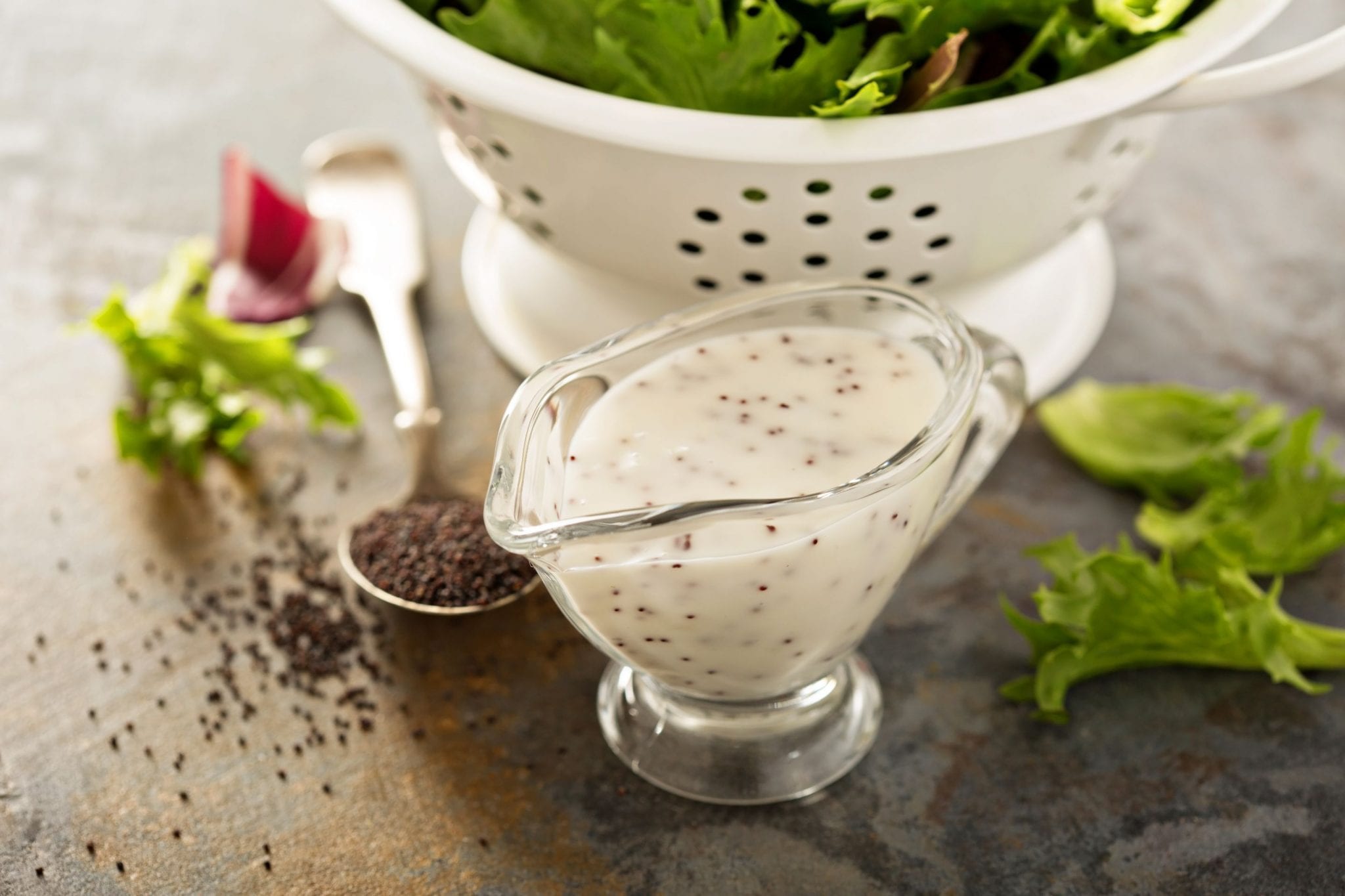 Cannabis poppyseed salad dressing only black surface with leaves and poppy seeds in the