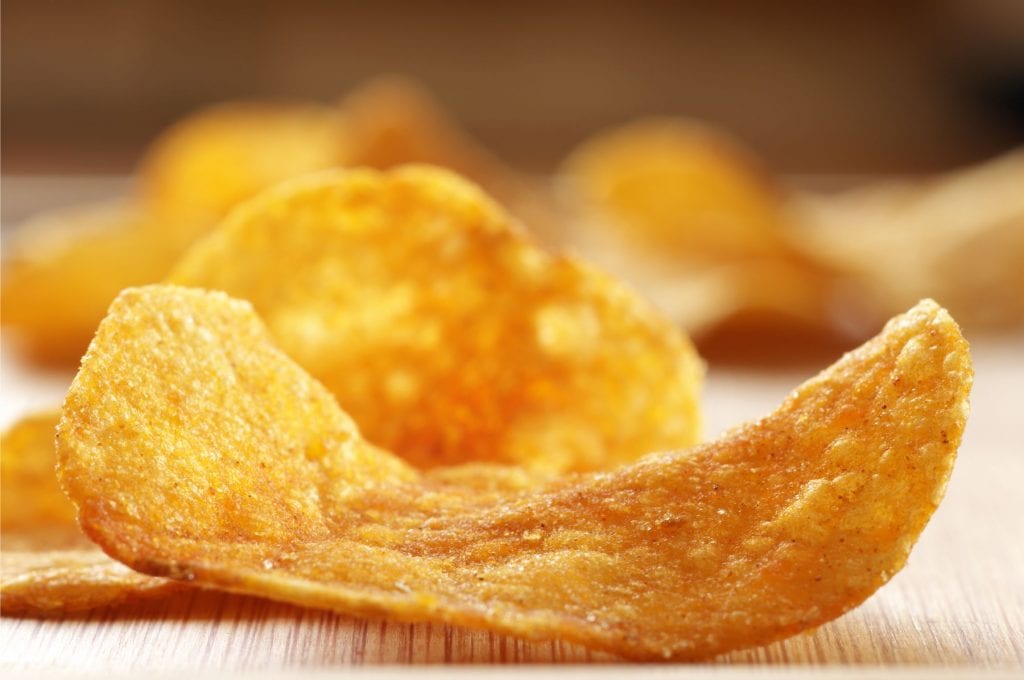 Macro shot of weed infused potato chip on the wooden countertop