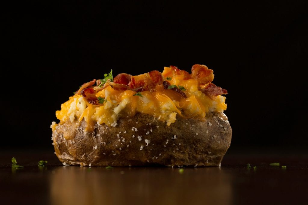 One cannabis infused twice baked potato on a black background