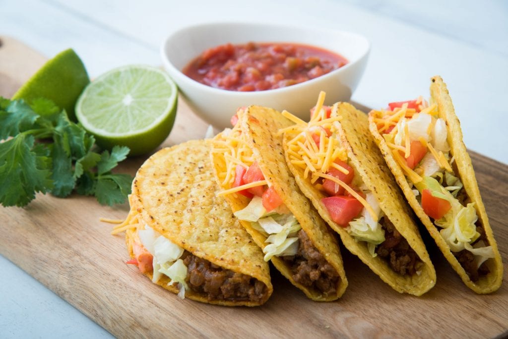 4 cannabis infused tacos with limes and salsa in the background