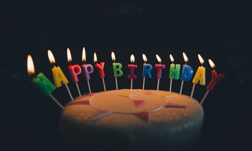 Pot birthday cake in a dark room With happy birthday candles that are all lit up