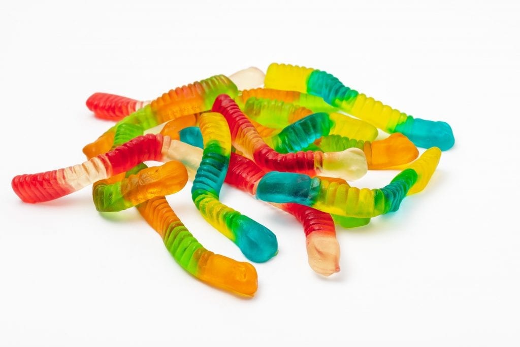 Gummy worms piled on top of each other on a white background