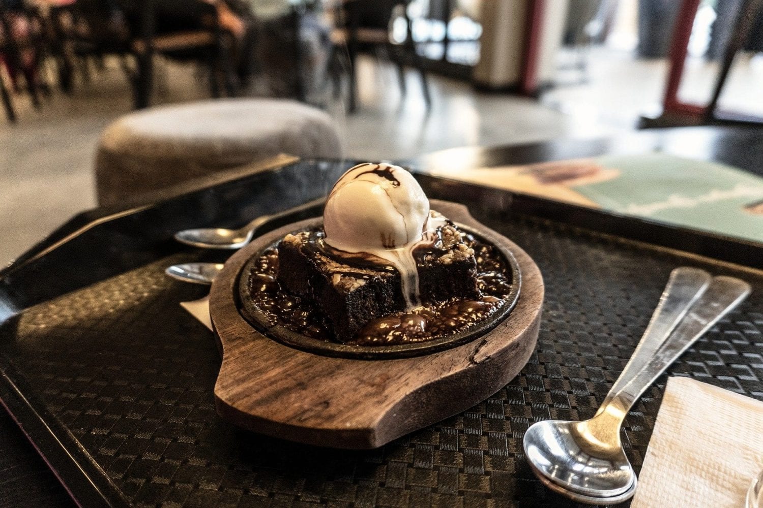 Cannabis infused chocolate lava cake with a scoop of ice cream on top of it and all of this is on a wooden plate