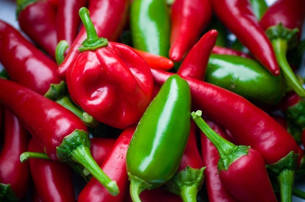 Macro shot of jalapeño peppers piled on top of each other