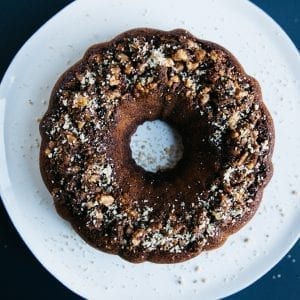 Overhead shot of cannabis infused coffee cake on a white plate with crumbs spread over the plate and all of this is on a blue table