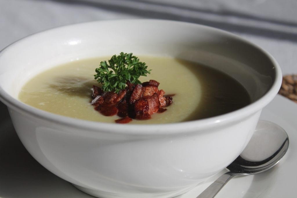 homemade soup with bacon bits and parcely in a white bowl