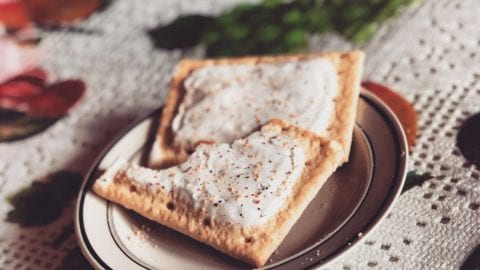 Two cannabis infused pop tarts on a plate which is on a tablecloth with berries