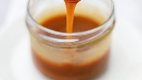 Cannabis infused caramel in a jar with a spoon scooping some of the caramel