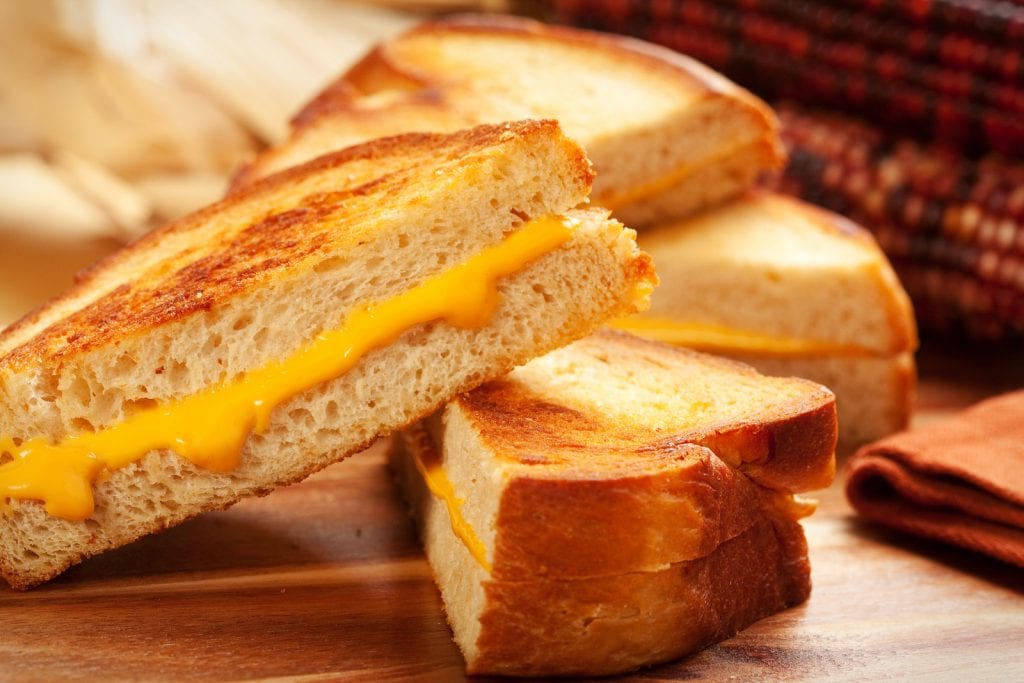 Macro of cannabis infused grill cheese on a wooden surface with more grilled cheese in the background