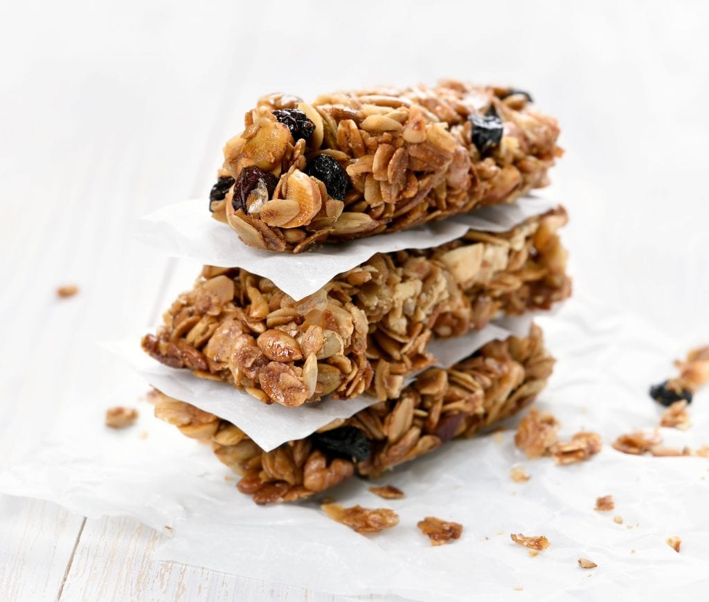 a stack of cannabis infused granola bars on a white wooden surface