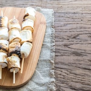 cannabis infused marshmallows on a wooden cutting board which is on a wooden surface