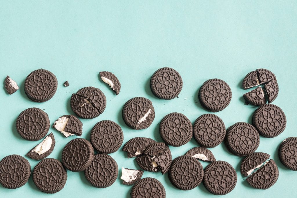 Oreo (chocolate and cream) cookies on blue pastel background, top view. a weed chocolate covered oreo recipe. 