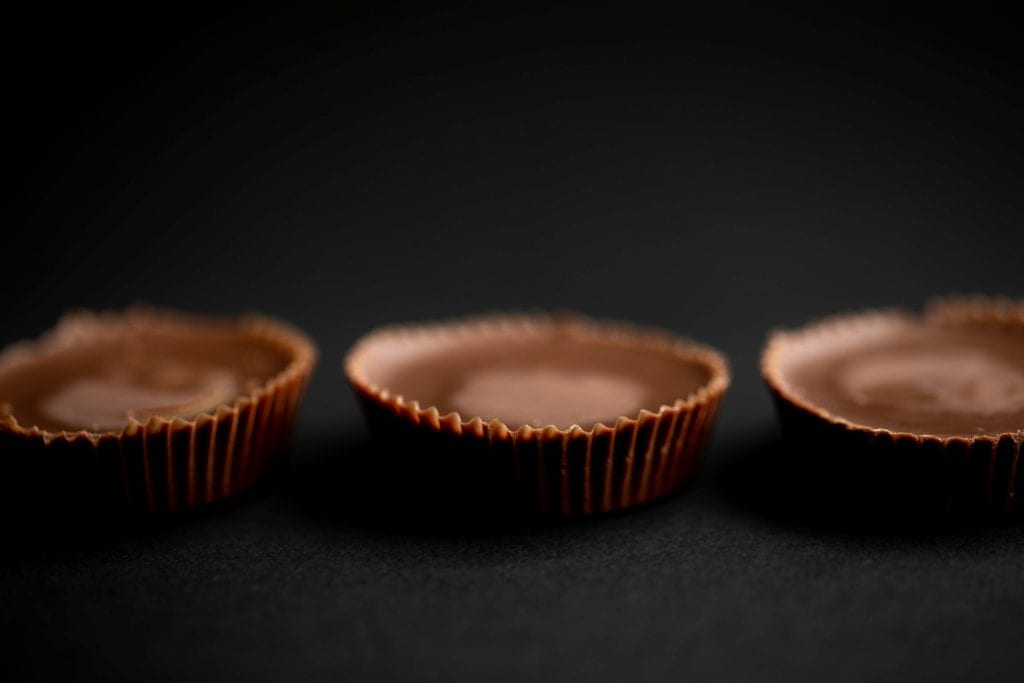 3 weed peanut butter cups on a dark black background macro