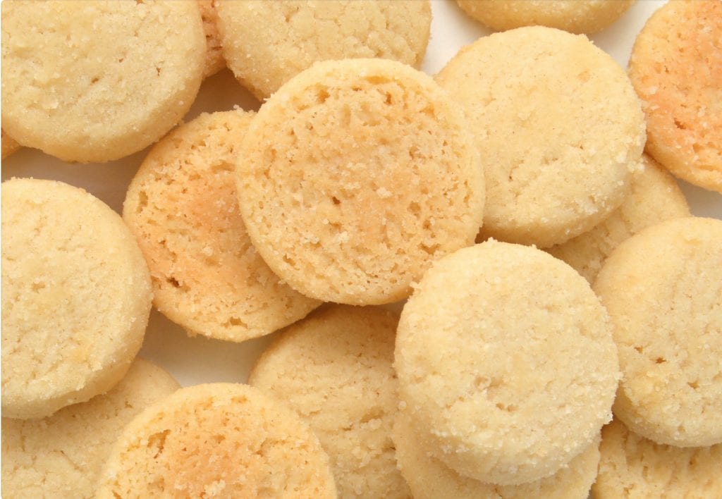 cannabis infused sugar cookies piled on top of each other on a white surface