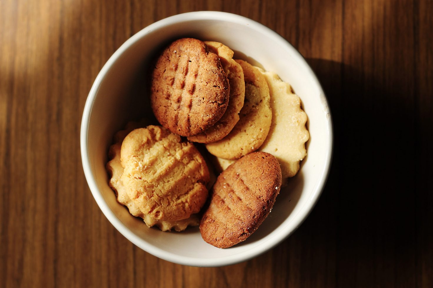 a bowl on a wooden surface with cannabis infused sugar cookies in it