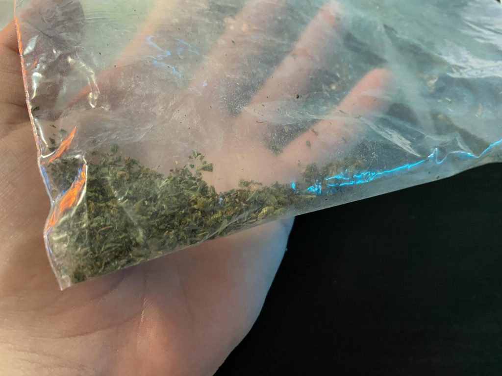 a zip lock baggy with shake weed in the bottom corner