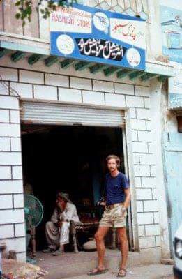 a tourist at a hashish store in pakistan, europe. The man stands in front of the door way. 